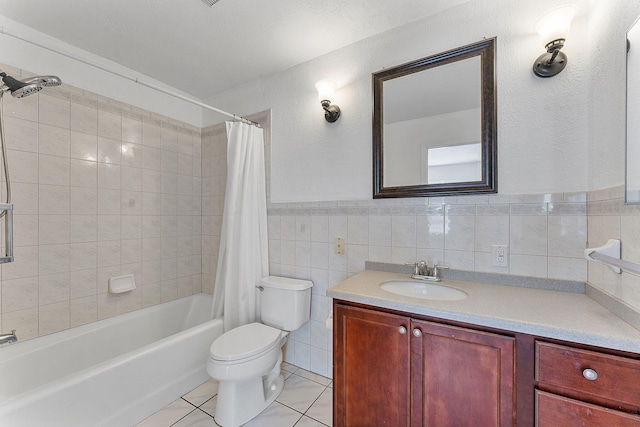 full bathroom featuring shower / bath combo, tile patterned floors, toilet, vanity, and tile walls