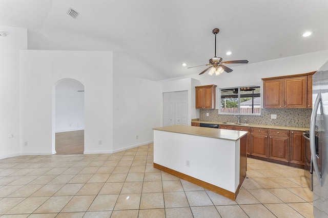 kitchen with ceiling fan, sink, light tile patterned floors, backsplash, and a kitchen island