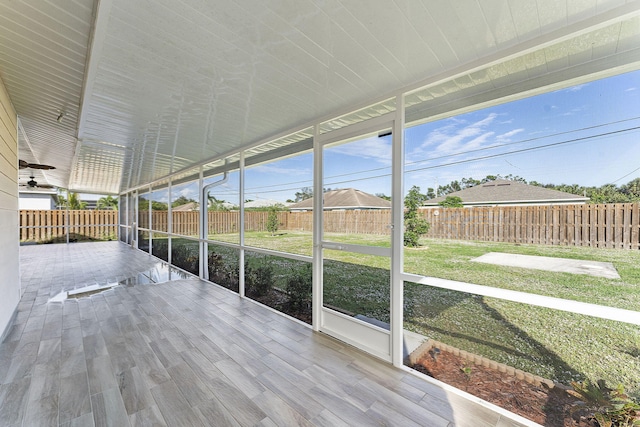 unfurnished sunroom featuring ceiling fan