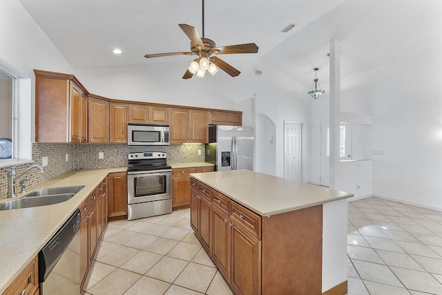 kitchen featuring appliances with stainless steel finishes, a center island, high vaulted ceiling, and sink