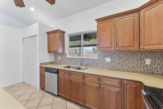 kitchen featuring dishwasher, stove, sink, tasteful backsplash, and light tile patterned flooring