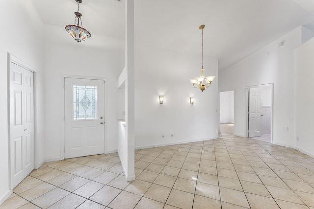 foyer with light tile patterned flooring, high vaulted ceiling, and a notable chandelier