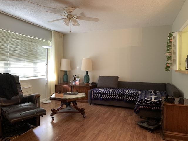 living room with ceiling fan, hardwood / wood-style floors, and a textured ceiling