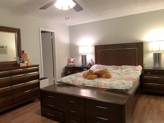 bedroom featuring a textured ceiling, dark hardwood / wood-style floors, and ceiling fan