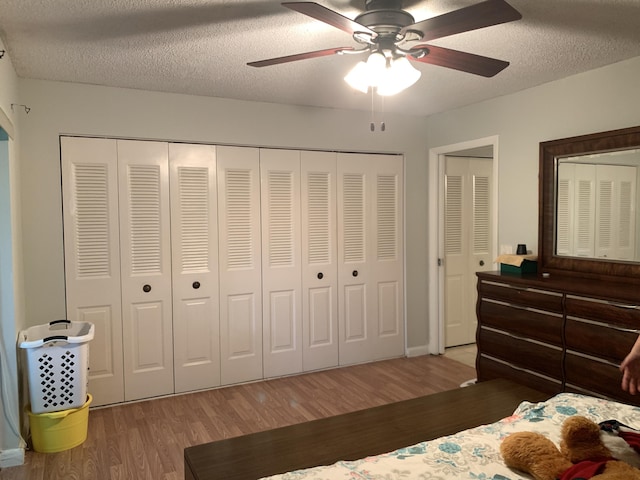 bedroom featuring hardwood / wood-style floors, a textured ceiling, and ceiling fan