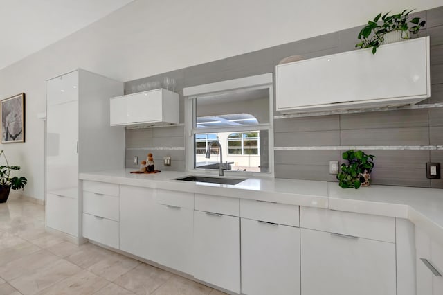 kitchen with white cabinetry, sink, and tasteful backsplash