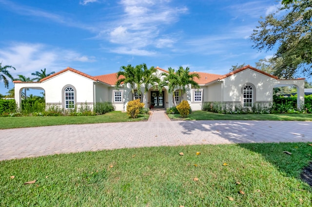 mediterranean / spanish home featuring french doors and a front lawn