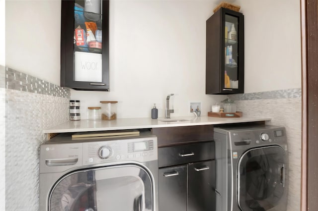 washroom with washer and clothes dryer, cabinets, and sink