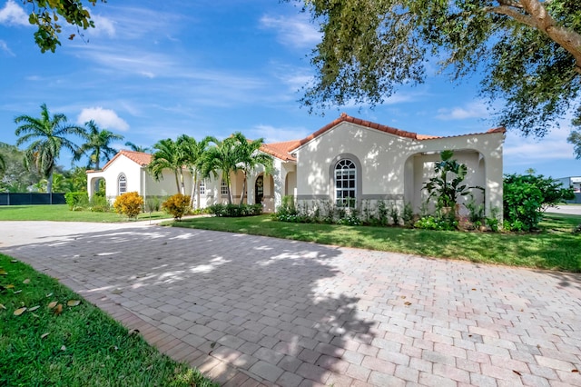 mediterranean / spanish-style house featuring a front yard