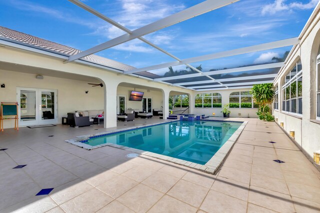 view of swimming pool featuring french doors, an outdoor hangout area, glass enclosure, and a patio