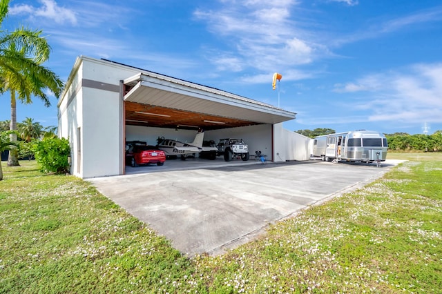 view of parking / parking lot featuring a carport and a yard