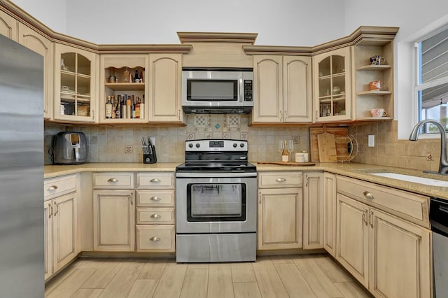 kitchen with backsplash, sink, light brown cabinets, and appliances with stainless steel finishes