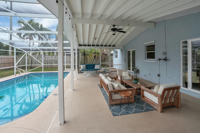 view of pool with a lanai, a patio, and an outdoor living space with a fire pit