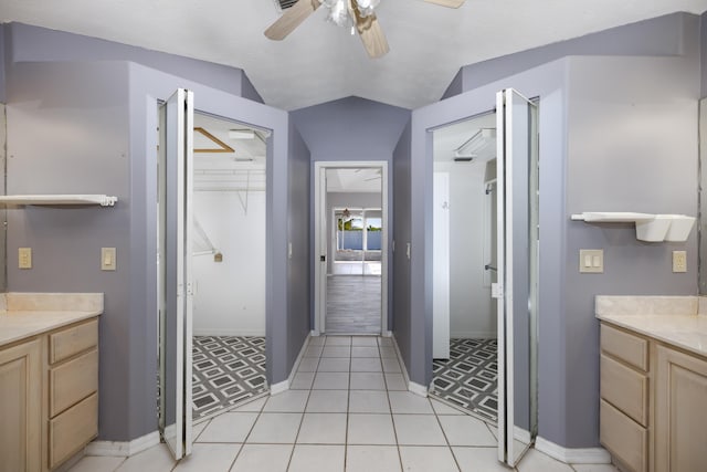 bathroom with tile patterned flooring, vanity, ceiling fan, and lofted ceiling