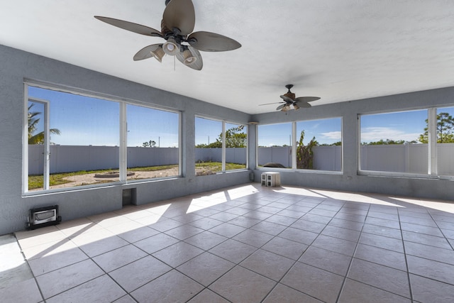 unfurnished sunroom featuring ceiling fan