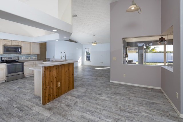 kitchen with ceiling fan, backsplash, light hardwood / wood-style floors, light brown cabinetry, and appliances with stainless steel finishes