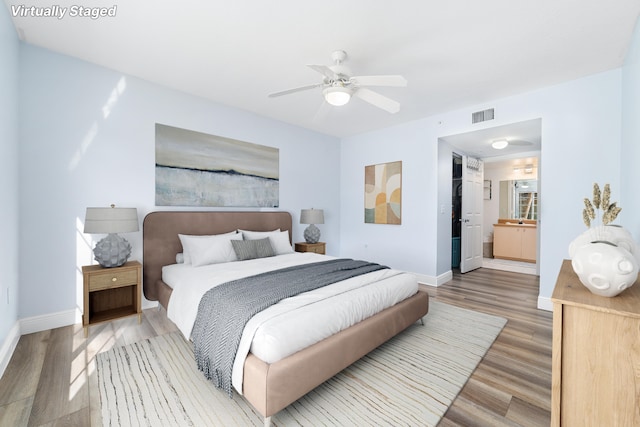 bedroom featuring wood-type flooring, connected bathroom, and ceiling fan