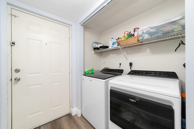 washroom with hardwood / wood-style flooring, a textured ceiling, and independent washer and dryer