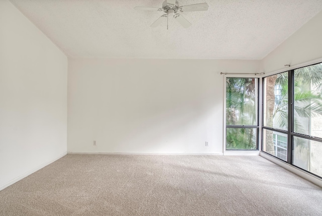 unfurnished room featuring a textured ceiling, carpet floors, ceiling fan, and lofted ceiling