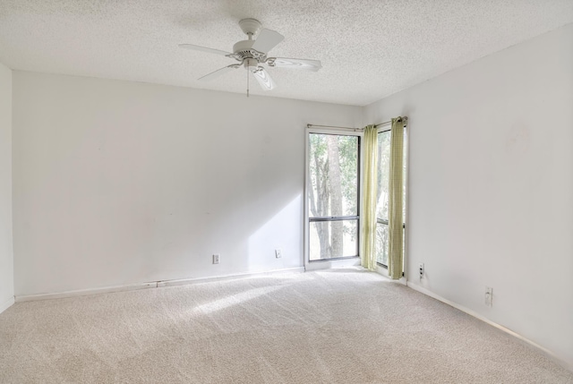 unfurnished room with carpet flooring, ceiling fan, and a textured ceiling