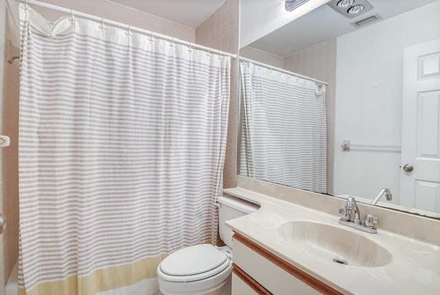 bathroom with a shower with curtain, vanity, and toilet