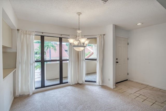 unfurnished dining area with light carpet, a chandelier, and a textured ceiling