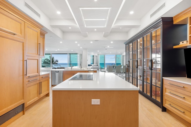 kitchen featuring a large island, light hardwood / wood-style floors, dishwasher, and black electric cooktop