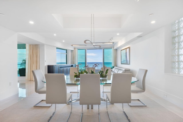 dining area with a chandelier, a water view, and expansive windows