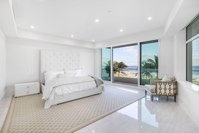 bedroom with access to outside, a water view, multiple windows, and a tray ceiling