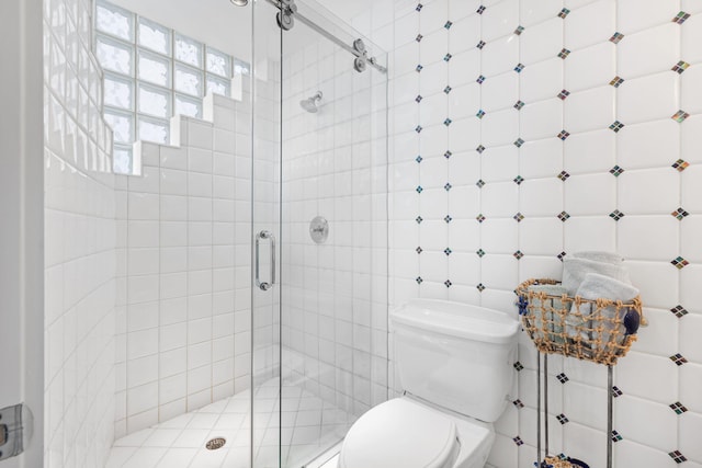 bathroom with walk in shower, tile walls, and toilet