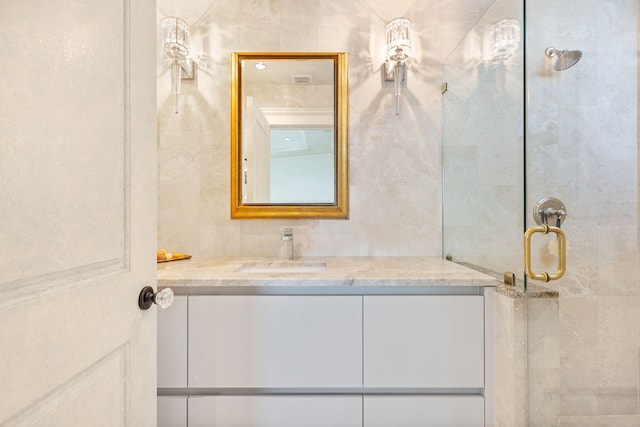 bathroom with vanity and a shower with shower door