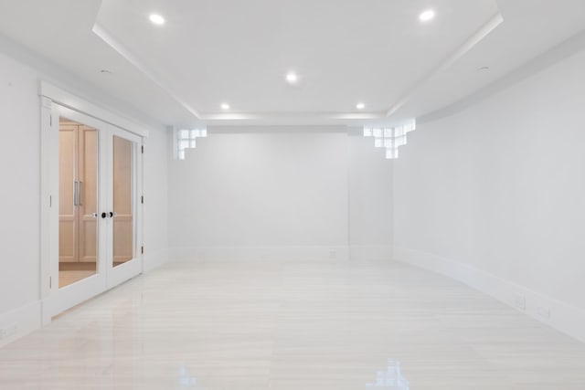 spare room featuring a raised ceiling and french doors