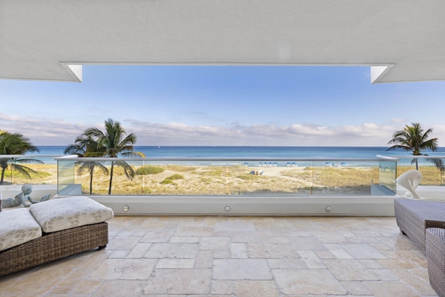 balcony featuring a water view and a view of the beach