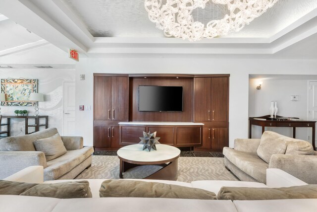 living room featuring a tray ceiling and a chandelier