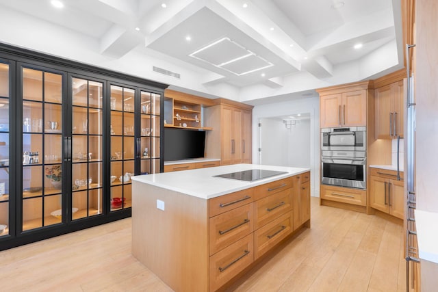 kitchen featuring black electric stovetop, a center island, light hardwood / wood-style flooring, and beam ceiling