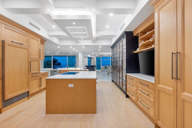 kitchen with light brown cabinetry, light hardwood / wood-style flooring, a kitchen island, and black electric stovetop