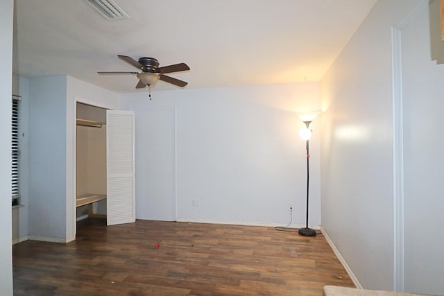 unfurnished bedroom with ceiling fan and dark wood-type flooring