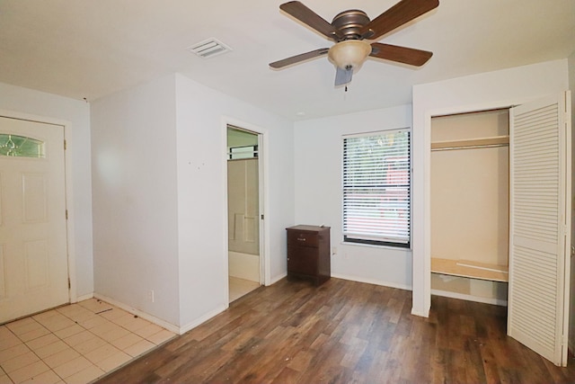 unfurnished bedroom with hardwood / wood-style floors, ceiling fan, and a closet