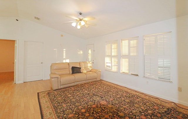 living room featuring ceiling fan, lofted ceiling, and light hardwood / wood-style flooring