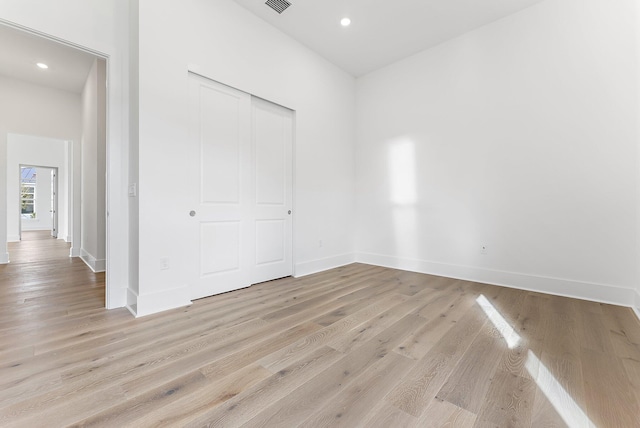 unfurnished bedroom with a closet and light hardwood / wood-style flooring