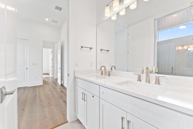 bathroom featuring hardwood / wood-style floors, vanity, and an enclosed shower