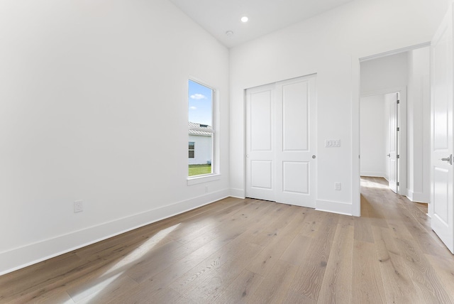 unfurnished bedroom featuring a closet and light hardwood / wood-style floors