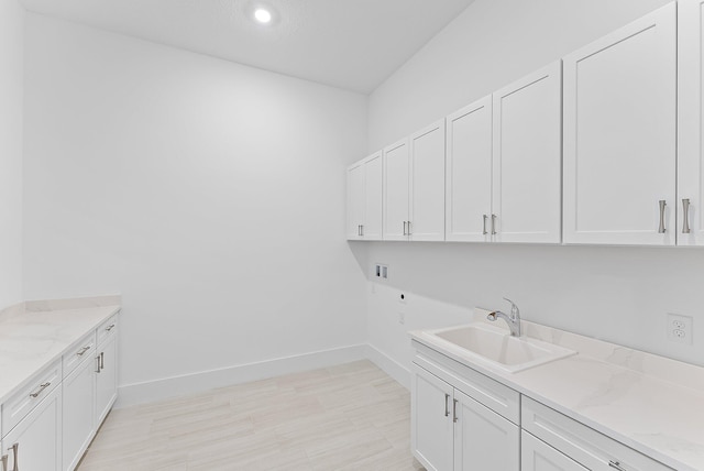 clothes washing area featuring cabinets, hookup for a washing machine, electric dryer hookup, and sink