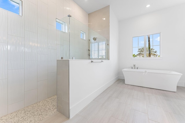 bathroom with a wealth of natural light and independent shower and bath