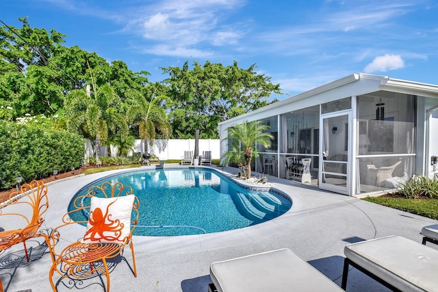 view of pool with a sunroom and a patio area