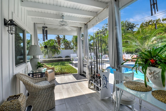 sunroom featuring ceiling fan and beamed ceiling