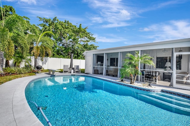 view of pool featuring a sunroom and a diving board