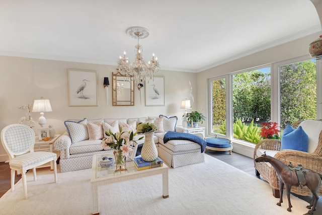 living room with an inviting chandelier, wood-type flooring, and ornamental molding