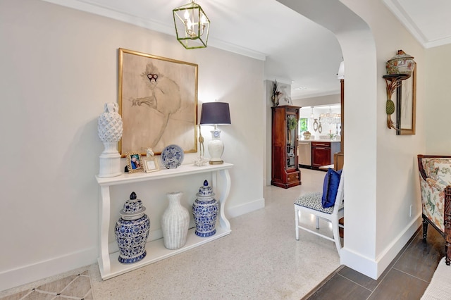 hall with crown molding and an inviting chandelier