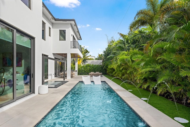 view of swimming pool featuring pool water feature and a patio